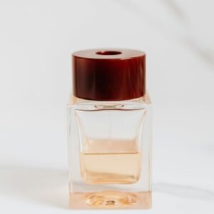 A luxury perfume bottle with a wooden cap on a minimal white background, embodying elegance and sophistication.