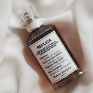 Maison Margiela Replica fragrance bottle on a white fabric background.